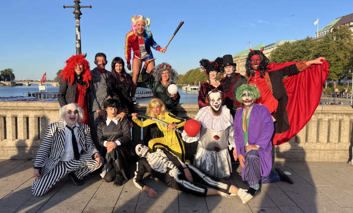 Menschen in diversen Halloween-Kostümen auf Brücke in Hamburg